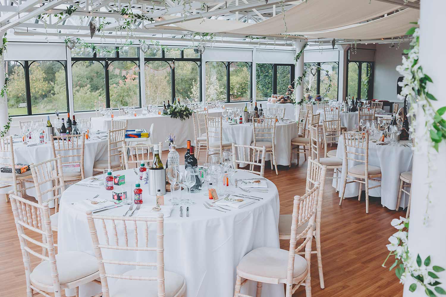 Tables set in the Hulme Conservatory in readiness for a wedding reception.