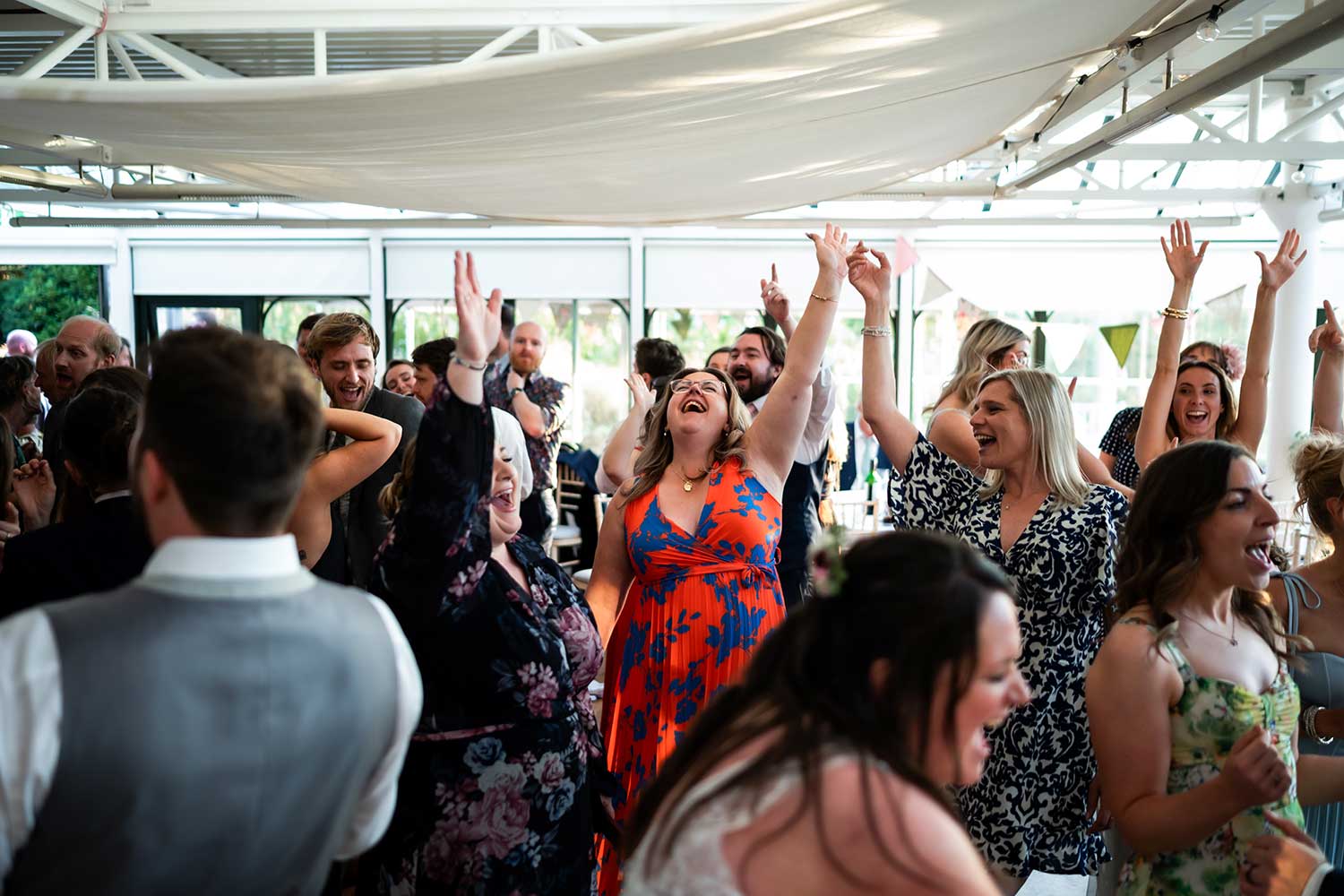 Wedding guests dancing during a wedding reception in the Hulme Conservatory.
