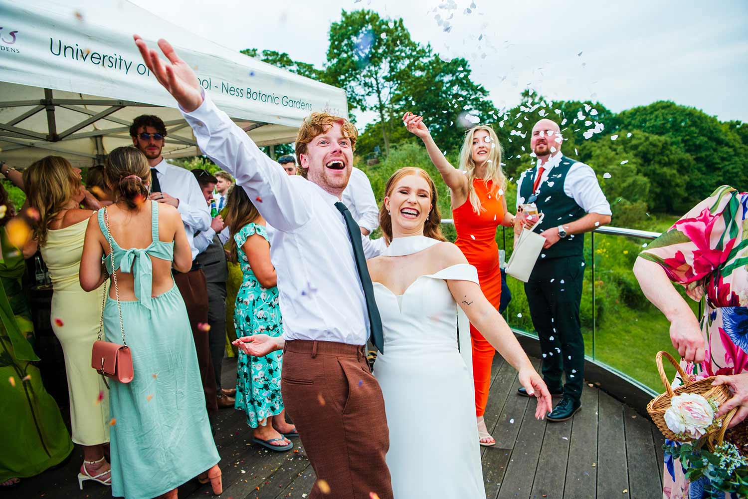 A couple celebrate their wedding, surrounded by their friends and family, on the Hulme Deck balcony.