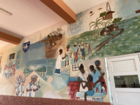 A murial showing local healthcare on the wall of a hospital in Biera