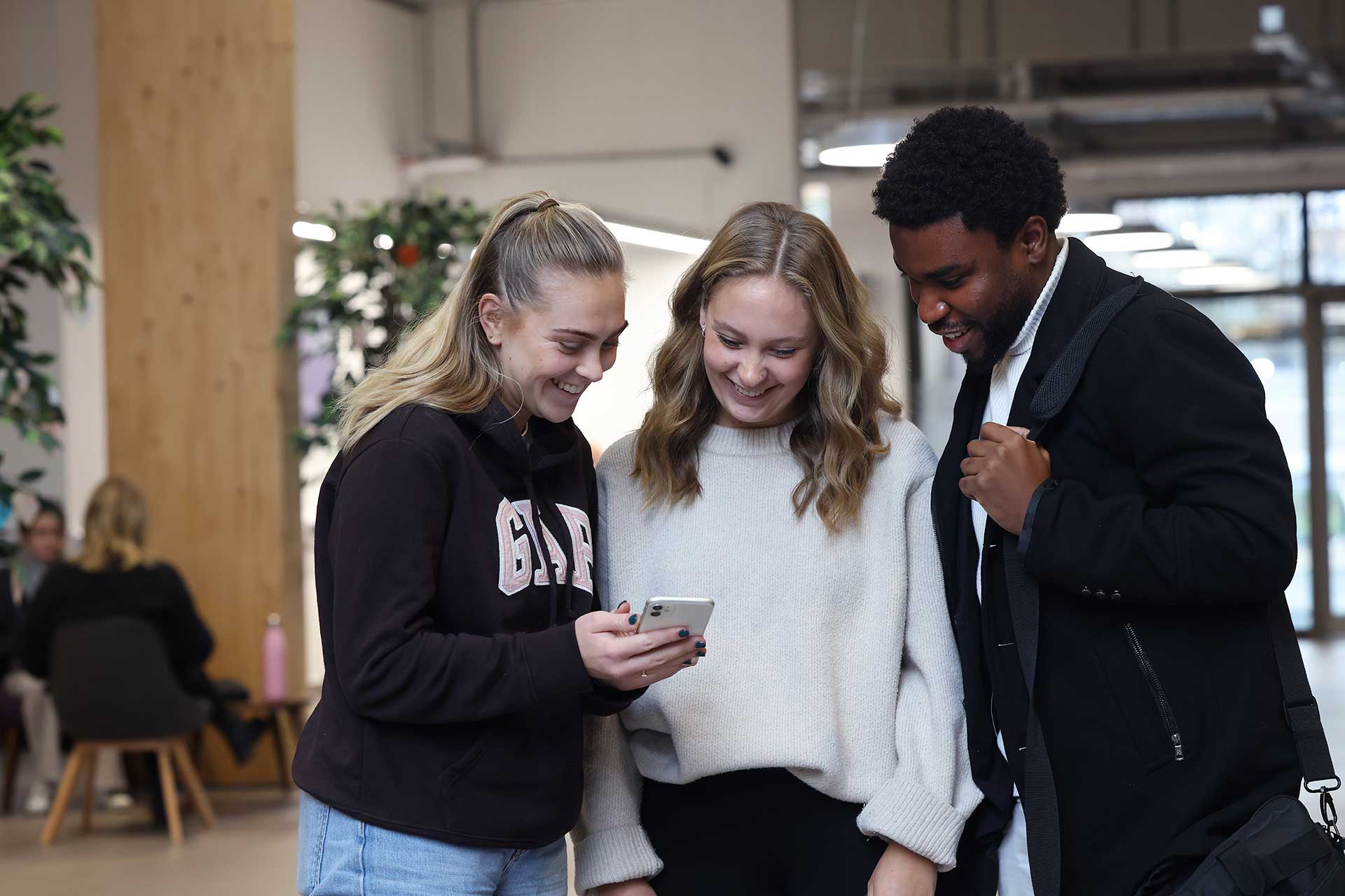 Three students in the foyer of the Law building.