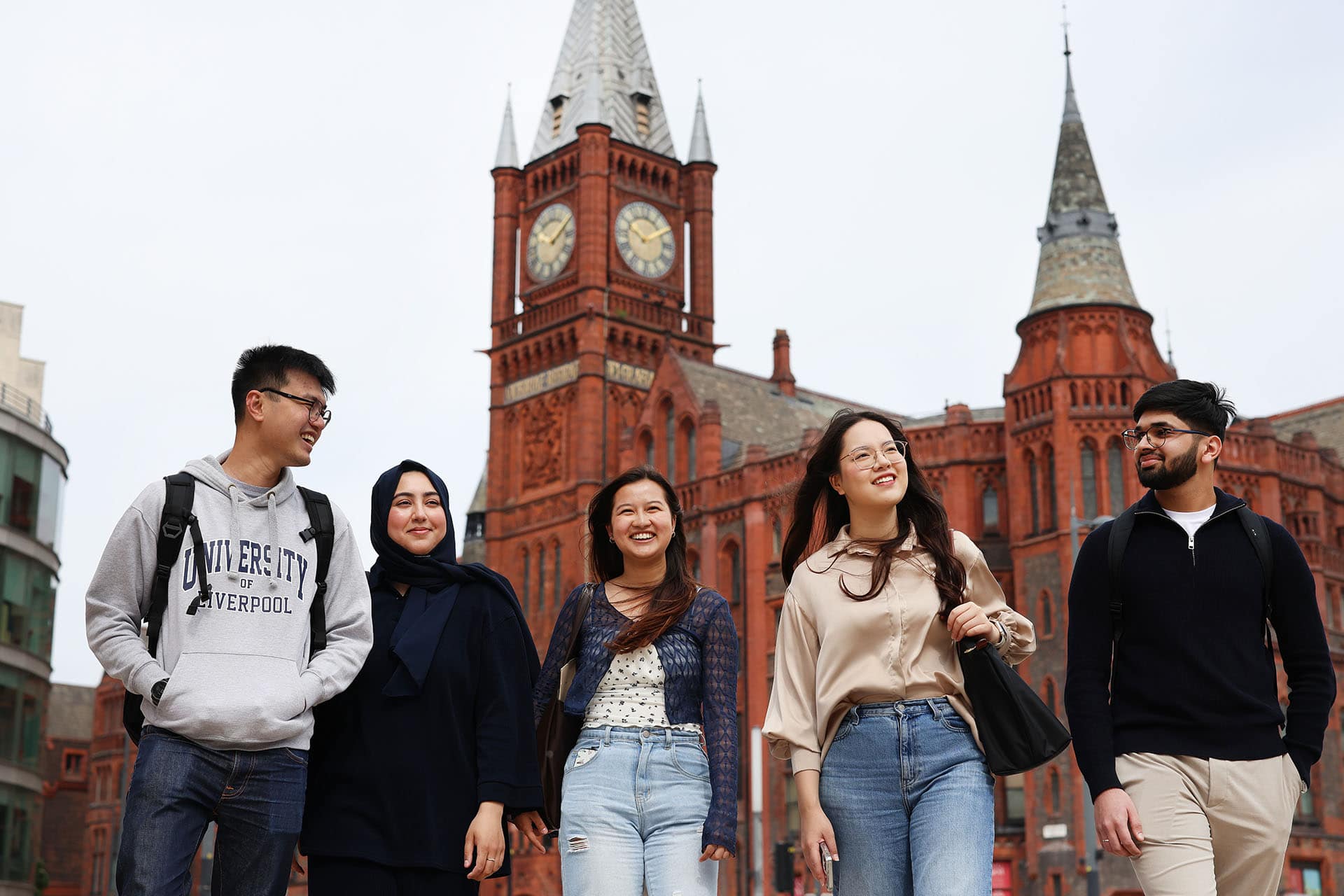 A group of students walk by the Victoria Gallery and Museum, all smiling