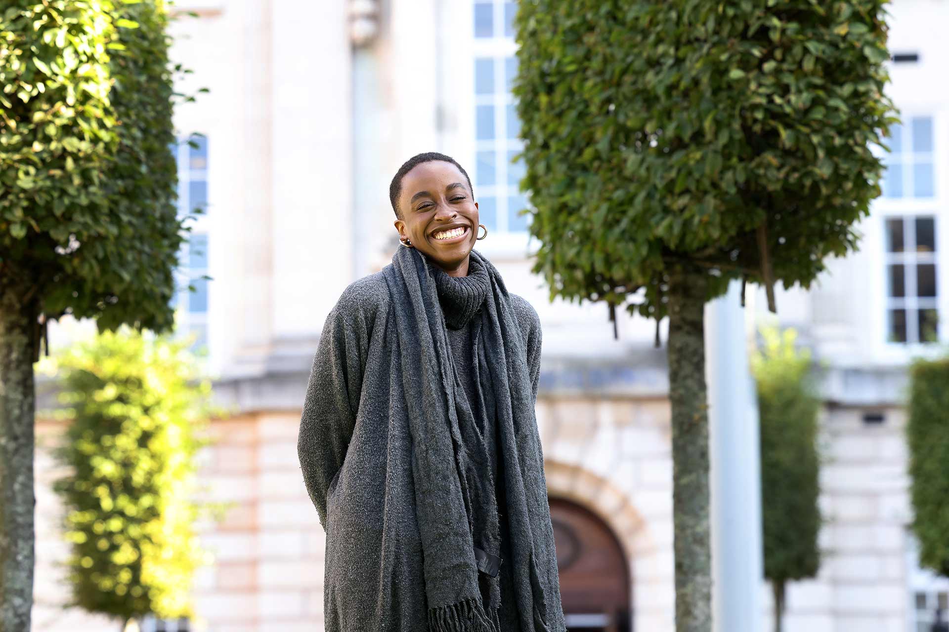 Portrait shot of a smiling student standing outside on the University of Liverpool campus