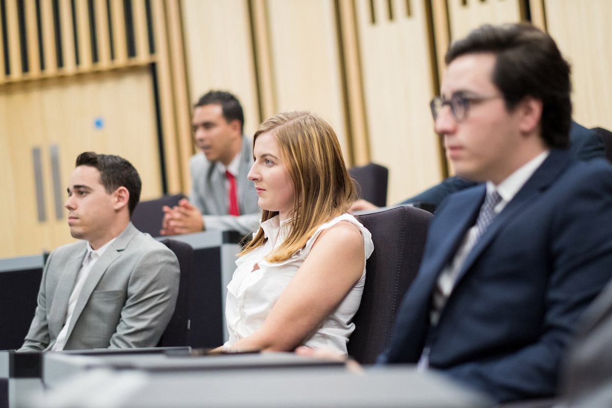 Four students listen attentively during a lecture.