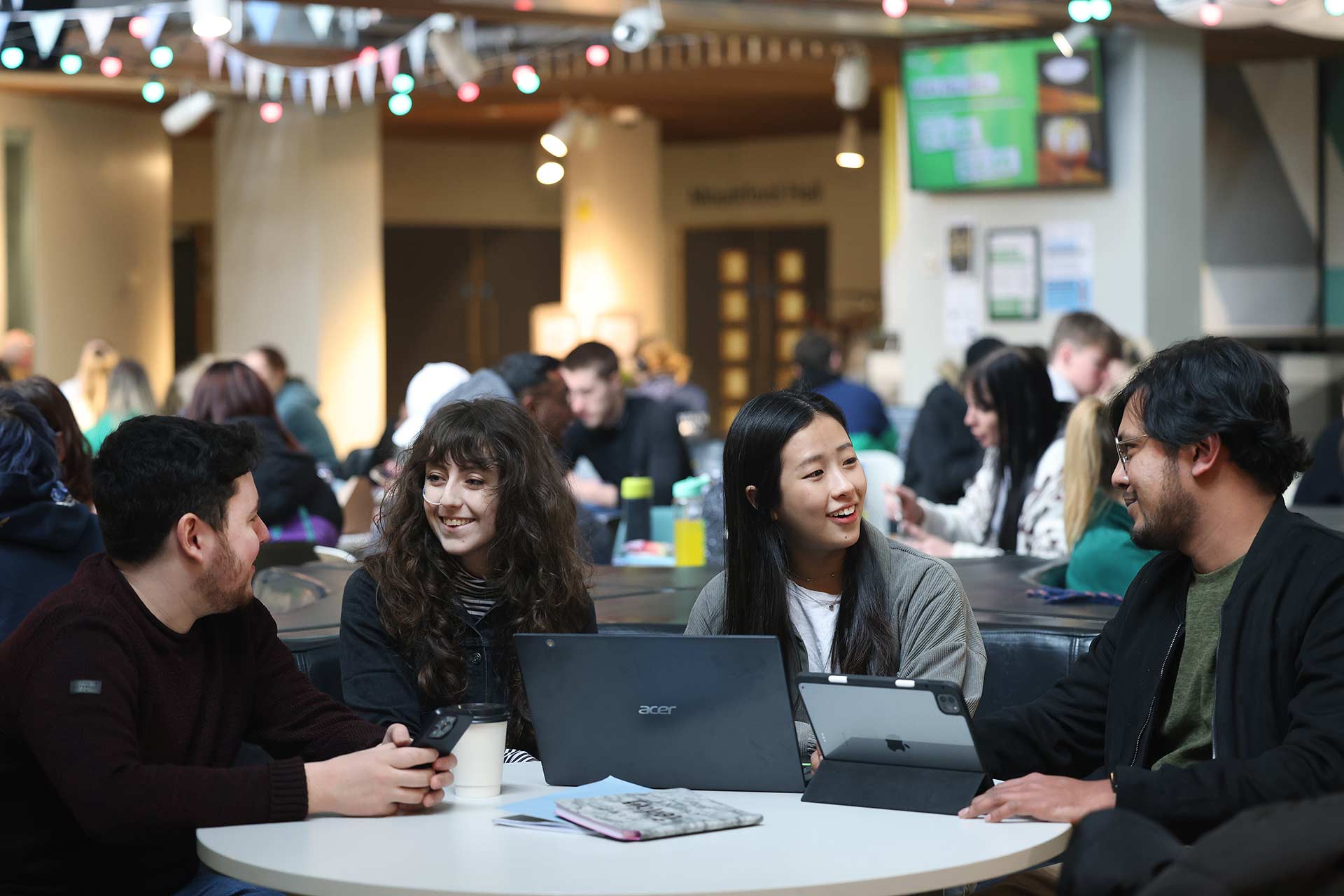 Four students sat round a table chatting in the Guild of Students.