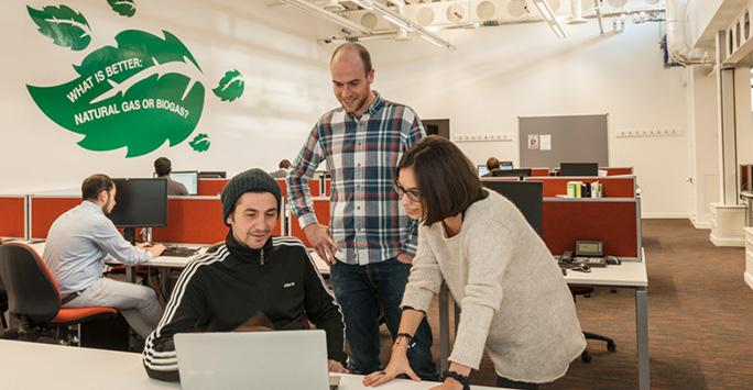 Group of researchers looking at a laptop