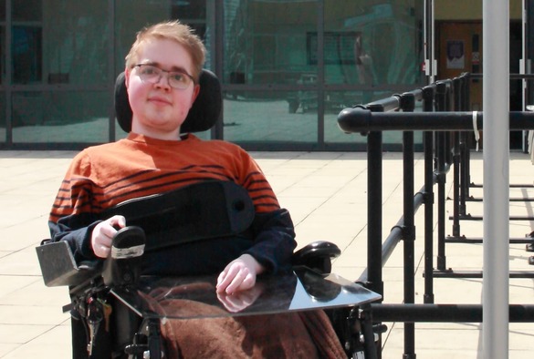 conor mcparkland in a wheelchair rests, appearing relaxed and contemplative in a park setting.