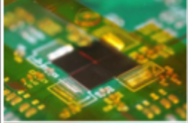 Close-up of a circuit board against a vibrant green background, showcasing intricate electronic components and connections.