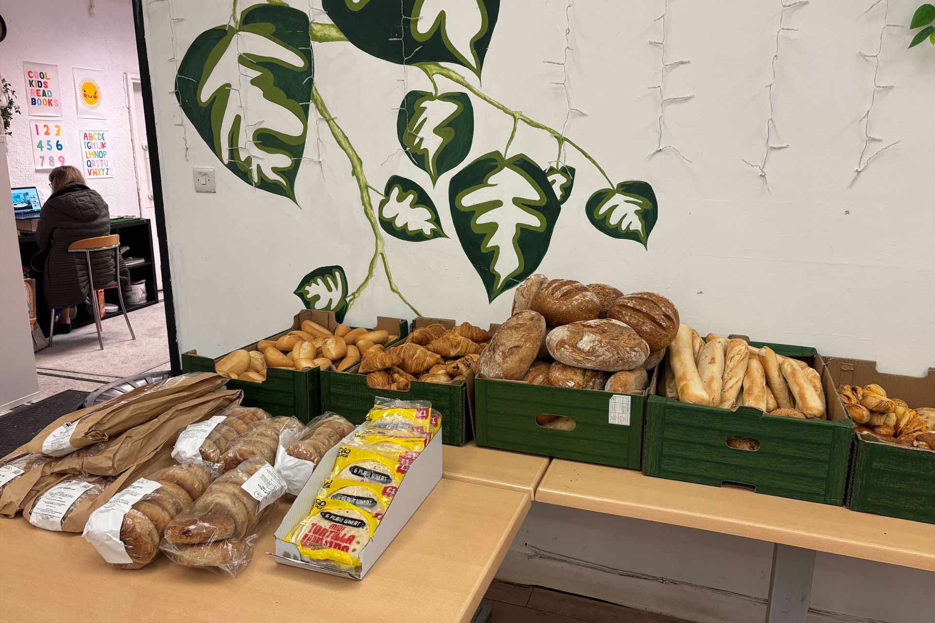 A table with piles of different types of bread on top of it.