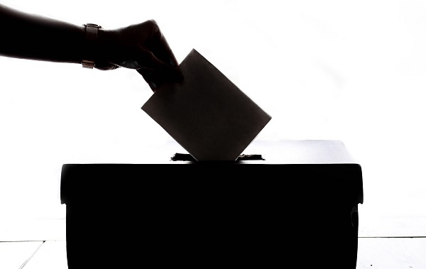 A silhouette of someone casting a vote