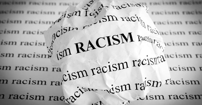 Crumpled paper with the word 'racism' printed on it
