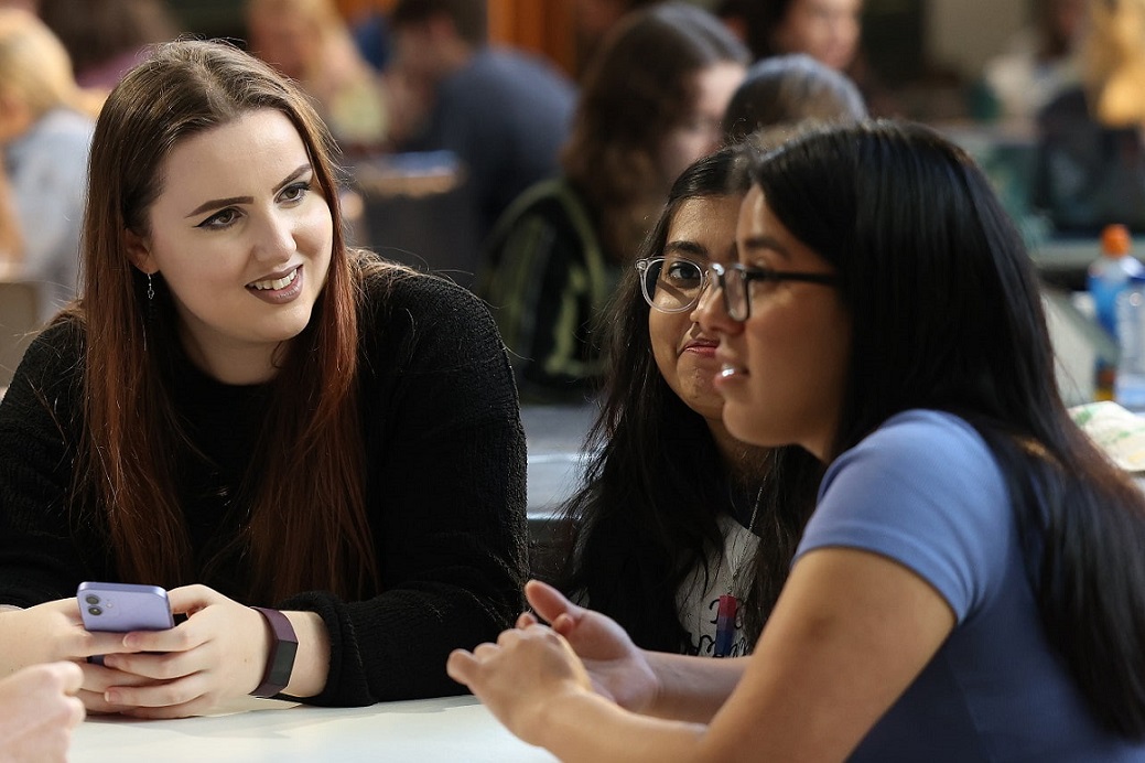 Students sat around a table having a discussion