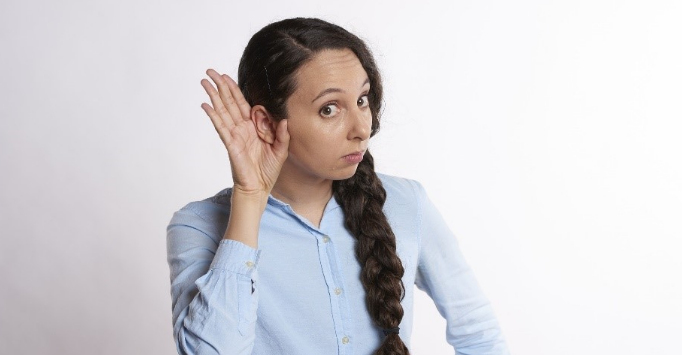 Woman holding her hand to her ear