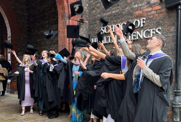Graduates from the School of Health Sciences celebrate outside the School