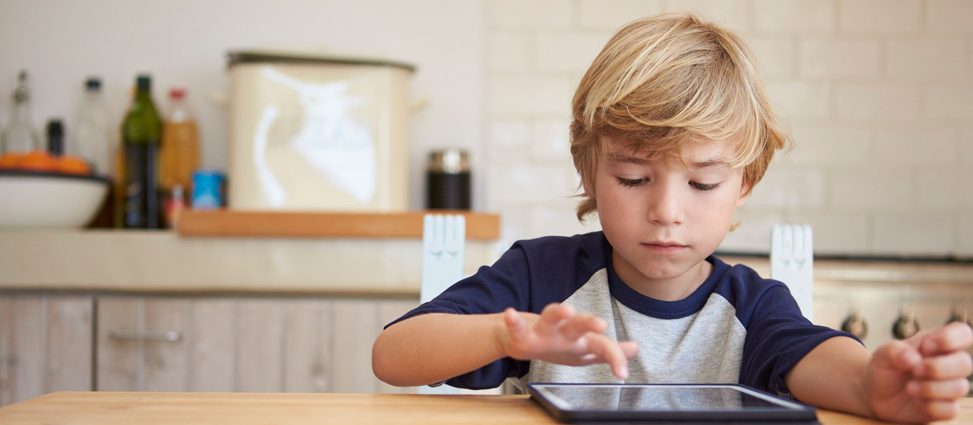 Young boy sitting at table with ipad