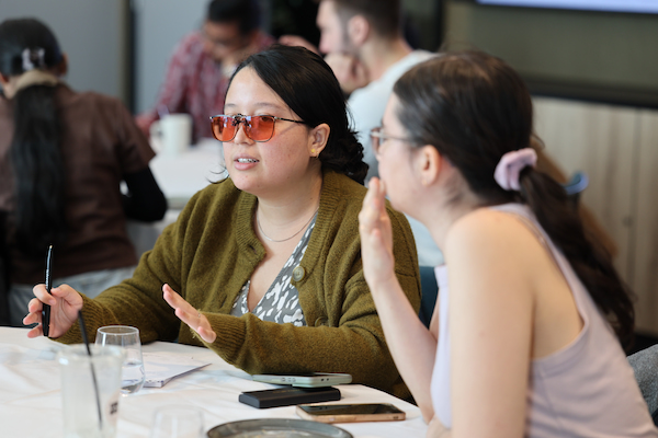 Two people sitting on a table and are discussing something.