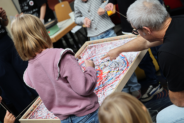 Children painting with marbles.