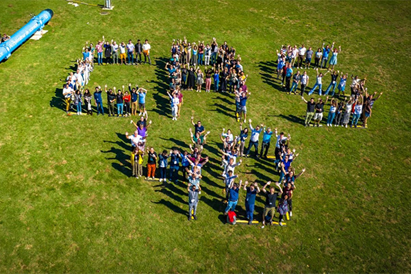 People forming the number 40 on a lawn.