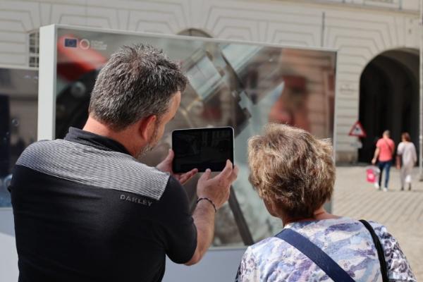 A person showing another person something on an iPAD.