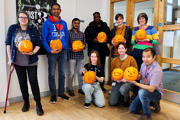 A group of people holding halloween pumpkins.