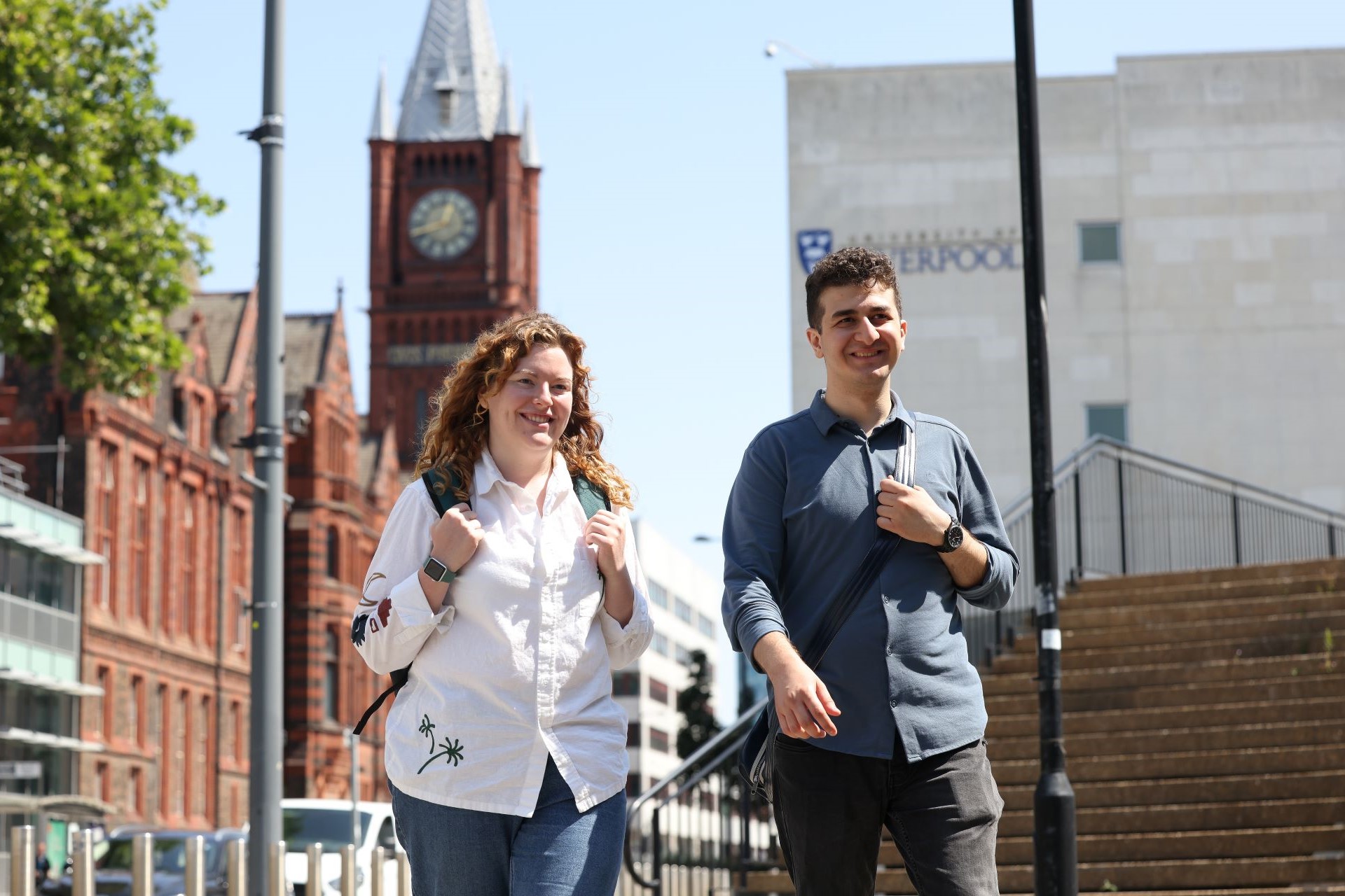 Two students walking across campus and having a conversation.