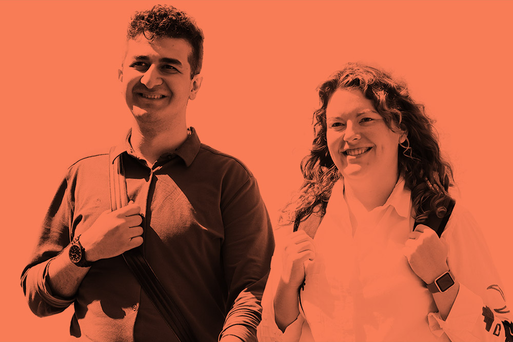 Two postgraduate students walking with an orange tint on the image