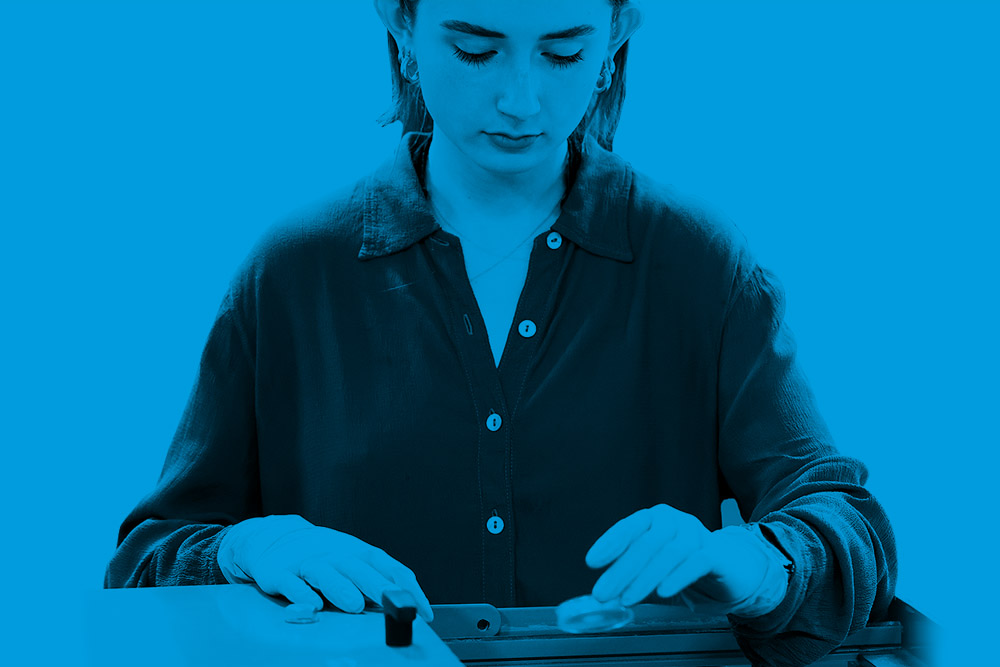 Blue tinted image of a student working in a lab