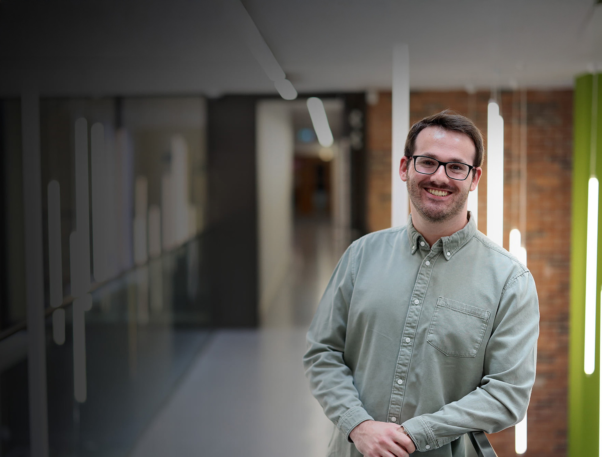 Smiling student in the Management School corridor with a blurred background