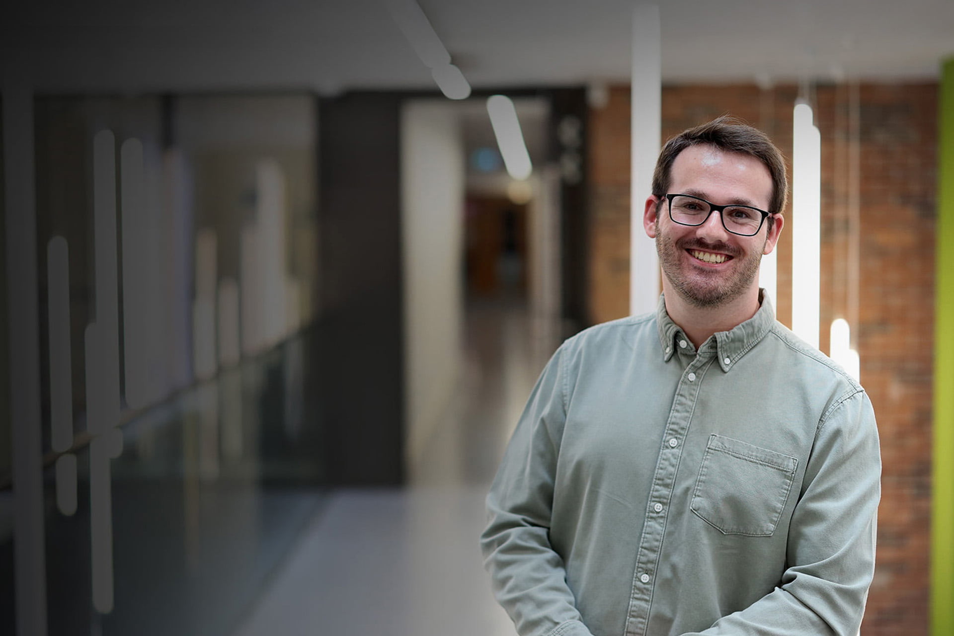 Student smiling standing in a corridor in the Management School
