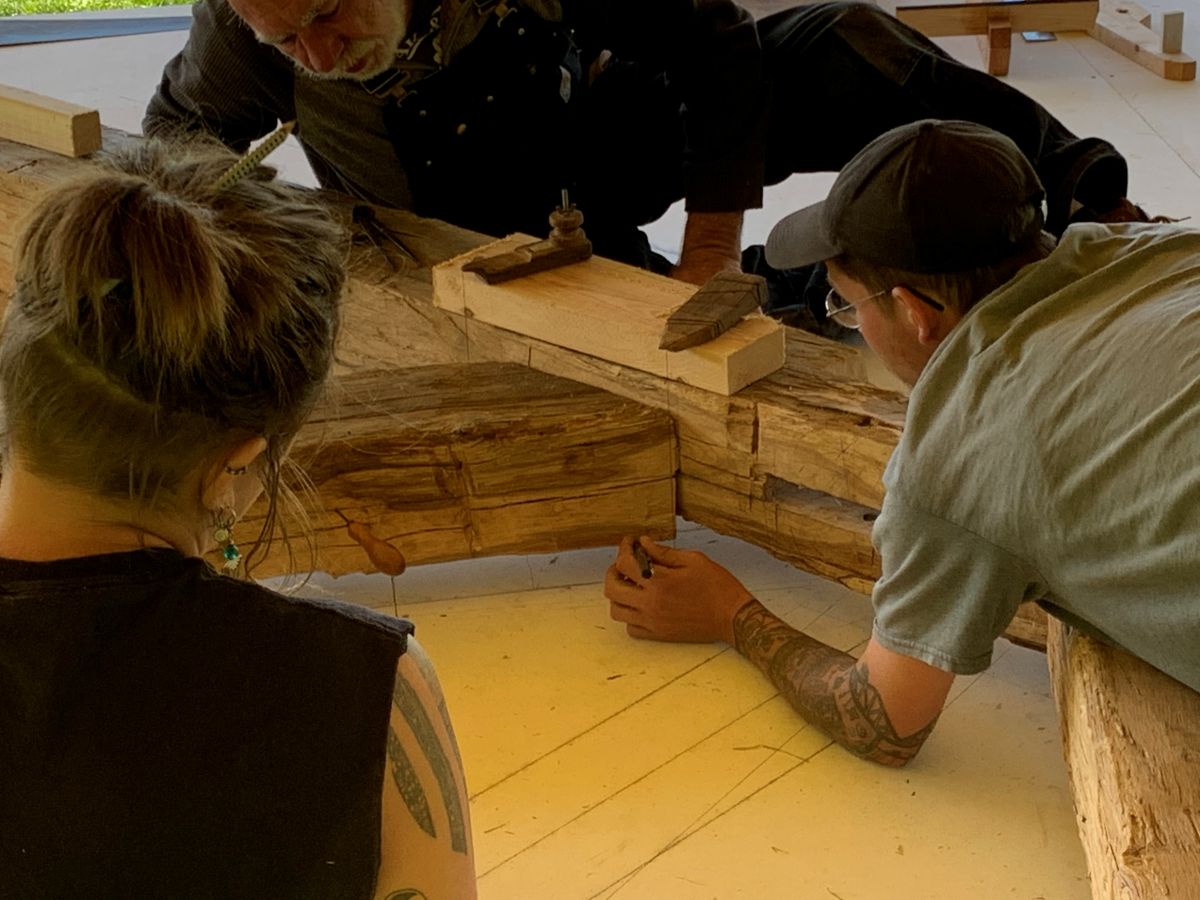 Researchers examine a wooden beam.
