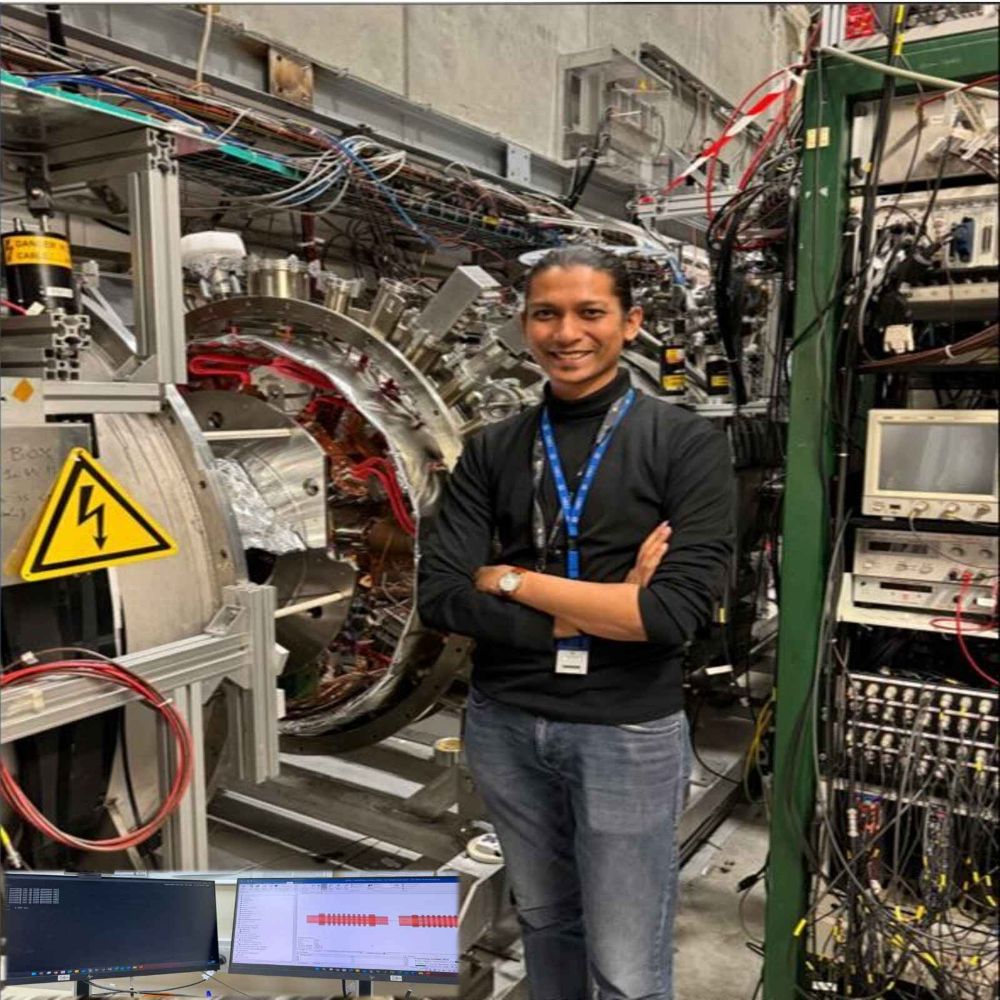 The image shows me standing beside the heart of the AEgIS experiment at CERN — the Penning–Malmberg trap, where antiprotons are confined and combined to form antihydrogen atoms. In the lower left, my digital twin of this same trap is displayed.