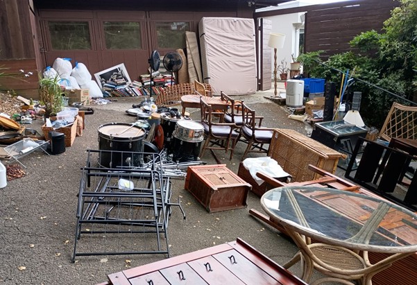 Furniture and possessions lie on a driveway
