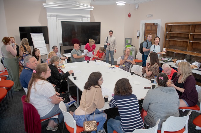 An image of a group of people sitting around a table having a discussion