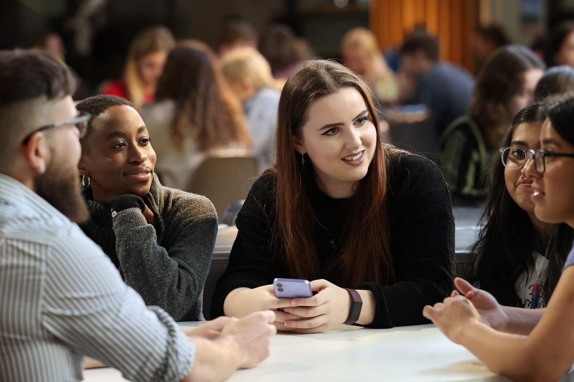 A diverse group of researchers collaborating around a table, symbolizing inclusive collaboration across sectors and career stages.