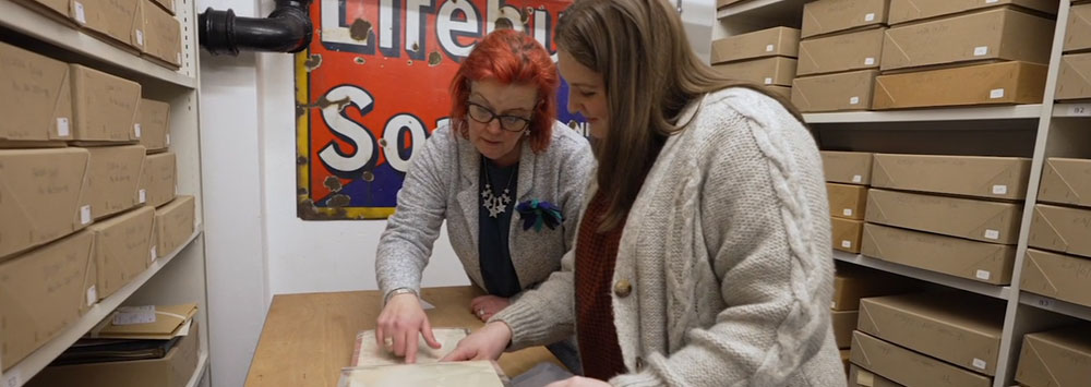 Two researchers looking at records