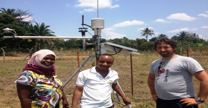Researchers standing in front of weather station 
