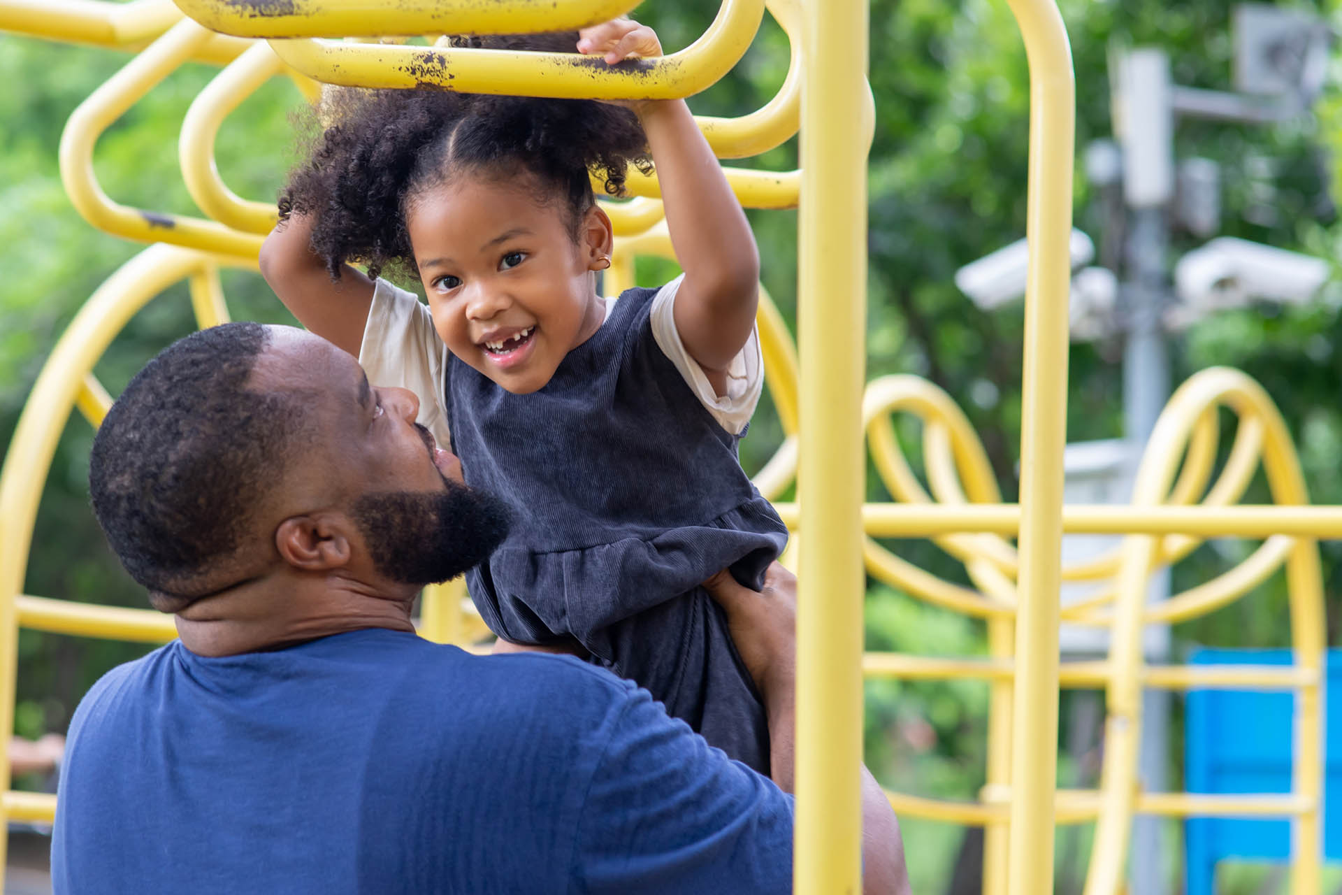 Dad playing with daughter at the playground