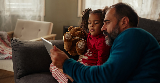 Father and daughter looking at tablet together