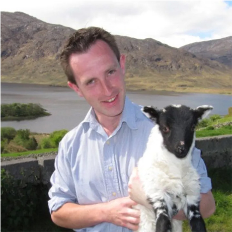 A photograph of Dr Peers Davies holding a sheep