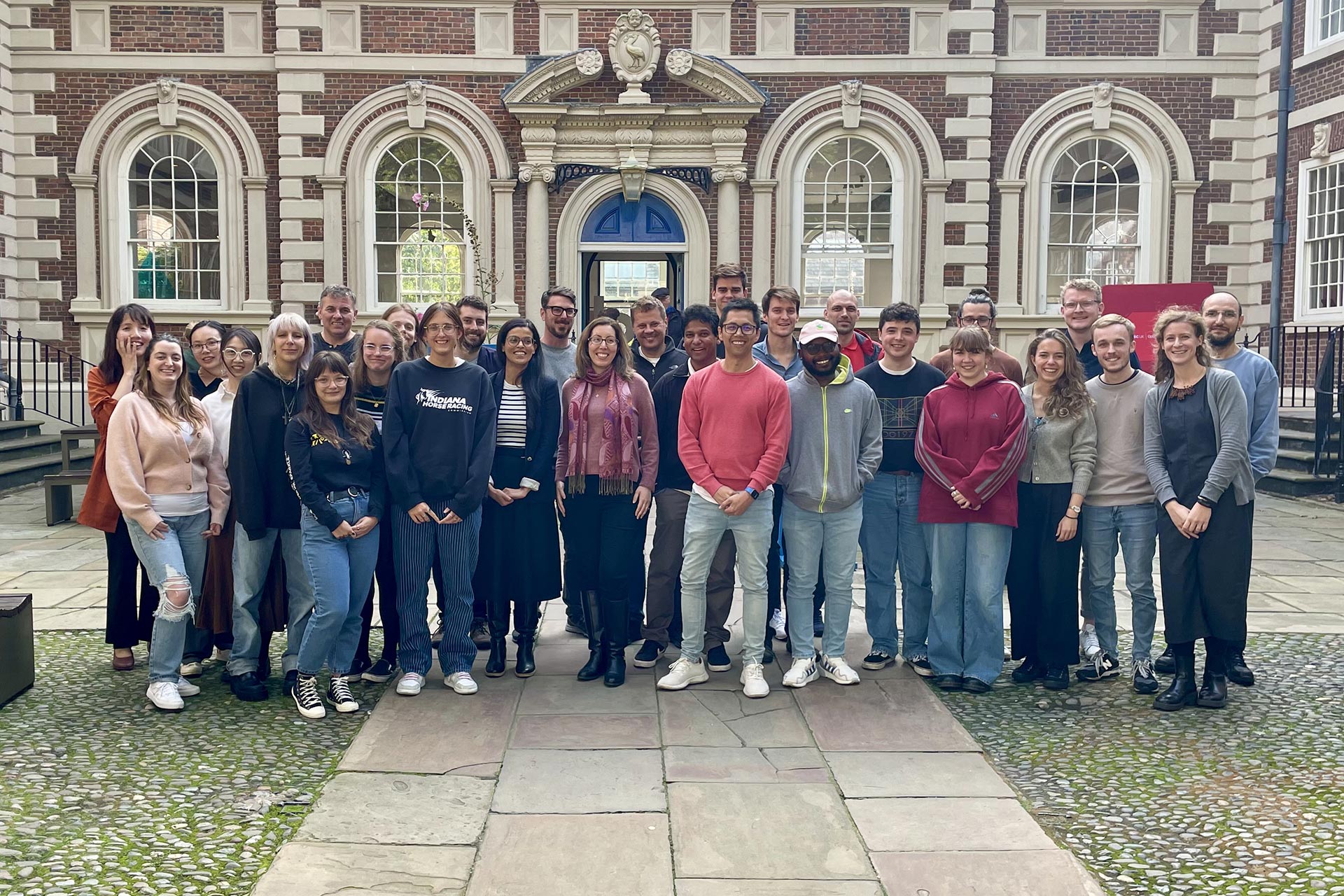A photograph of the team from the Geographic Data Science Lab in Liverpool. They are standing in front of the Bluecoat Building.
