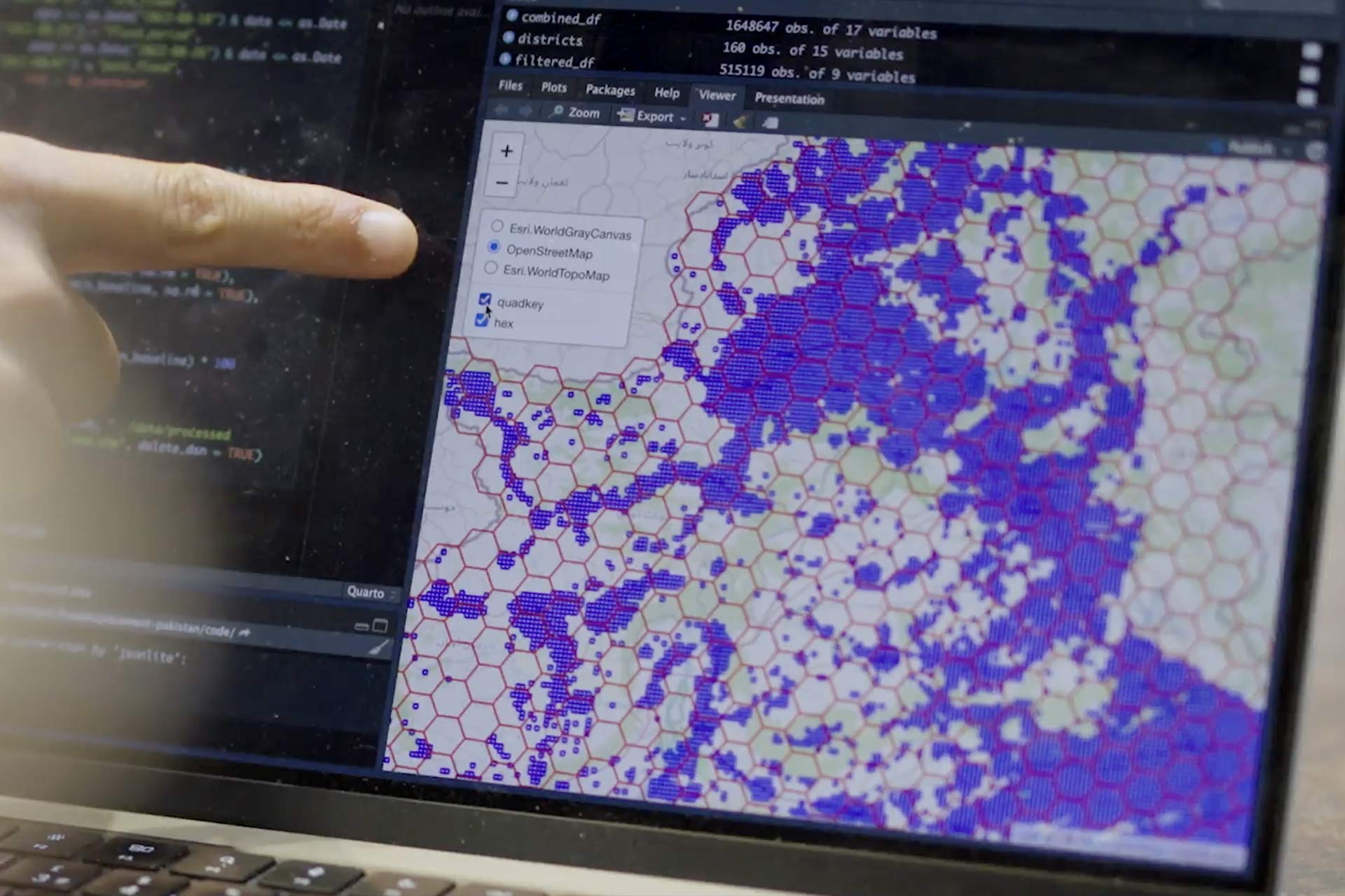 A finger pointing at a laptop screen, on which there is an image of an interactive map