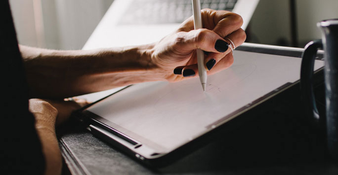 Woman's hand writing on a tablet