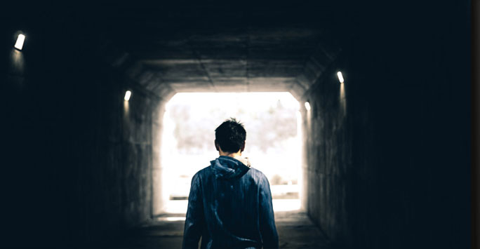 Young person standing in an underpass