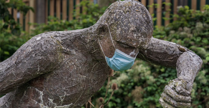 A statue wearing a medical face mask