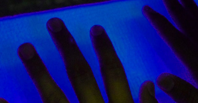 Hands against a blue light