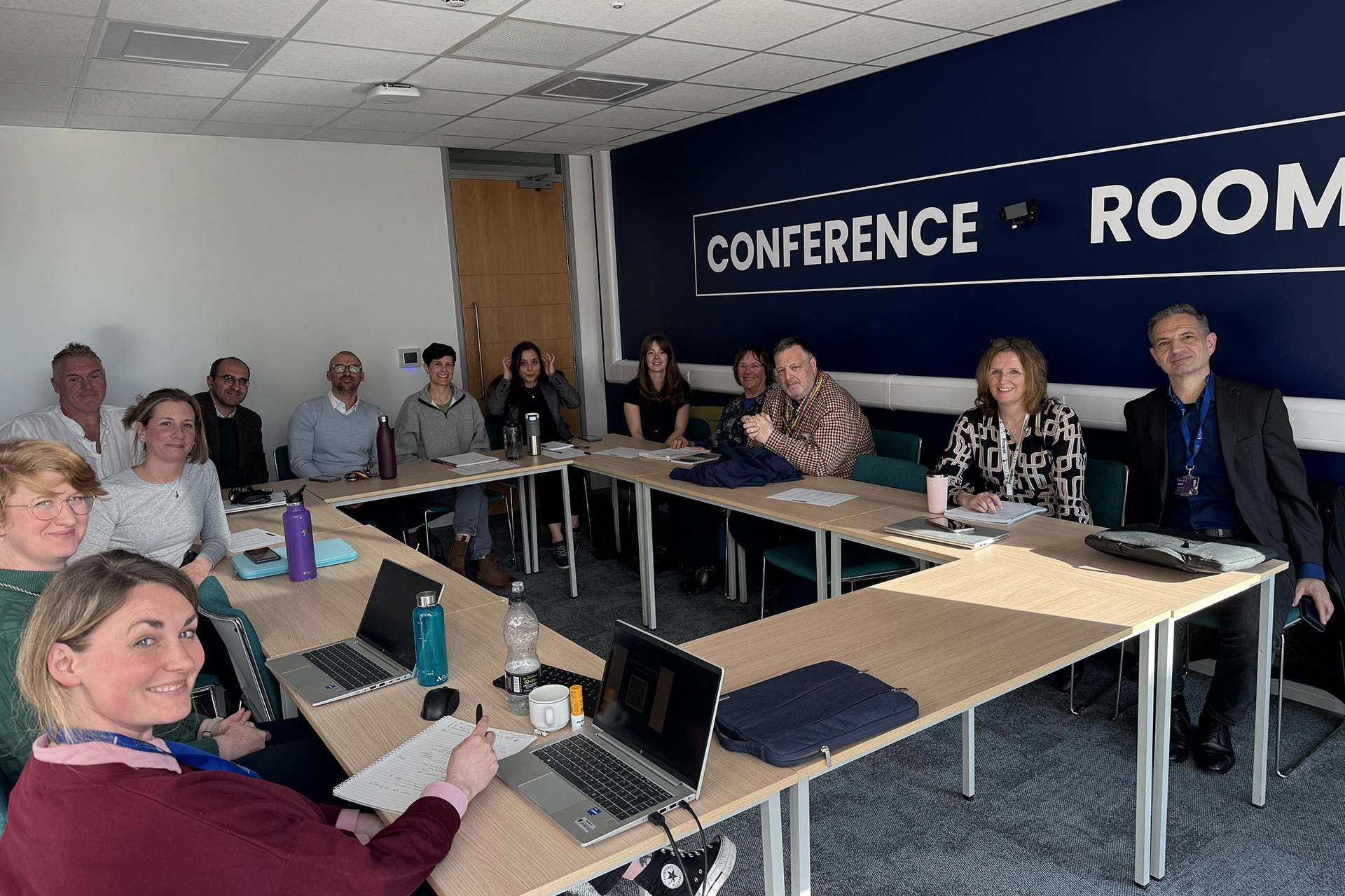A photograph of a group of people sitting in a conference room during an event at the Interdisciplinary Centre for Sustainability Research.
