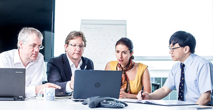 Group of people in a meeting looking at computer screen