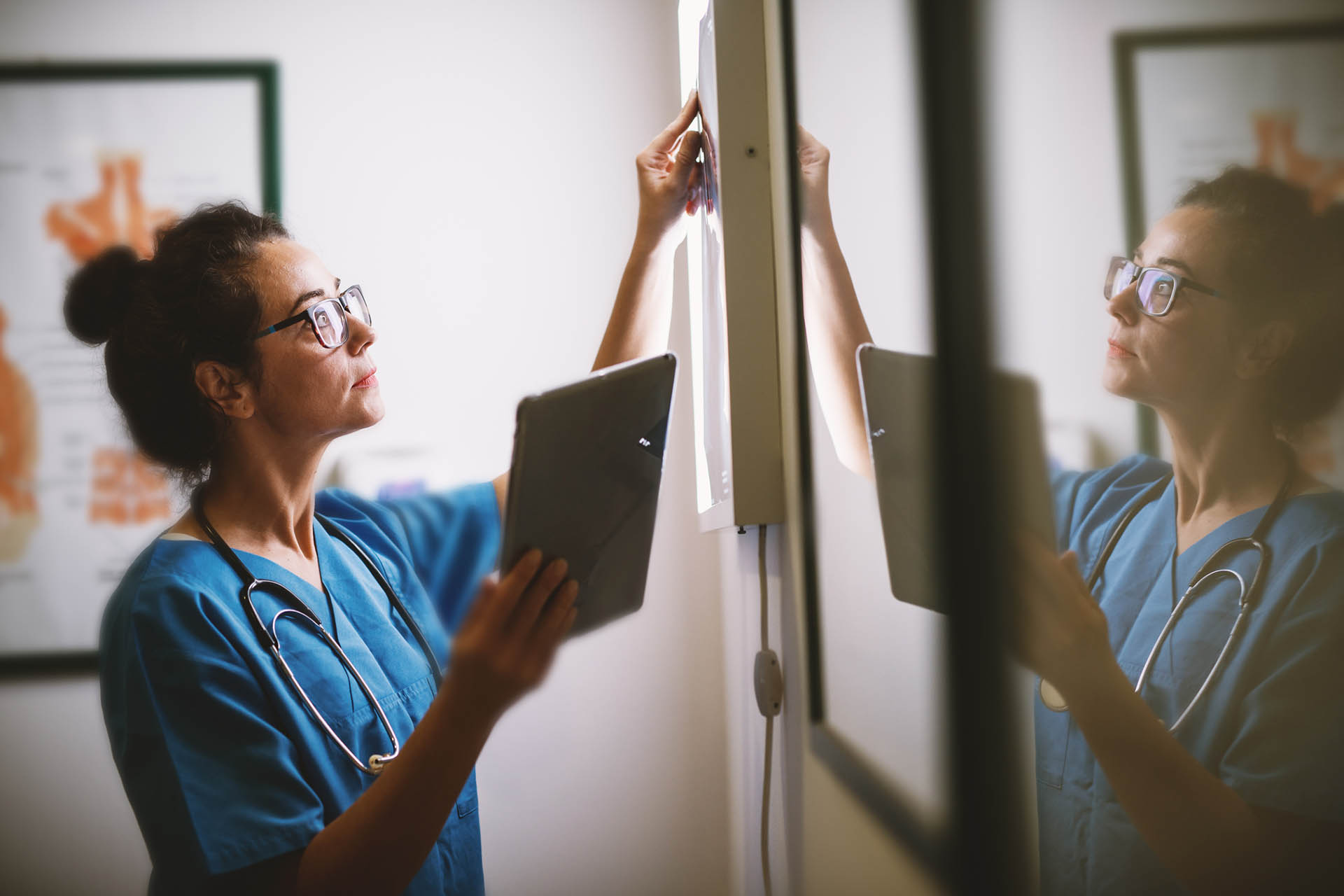 Female doctor looking at iPad and screen