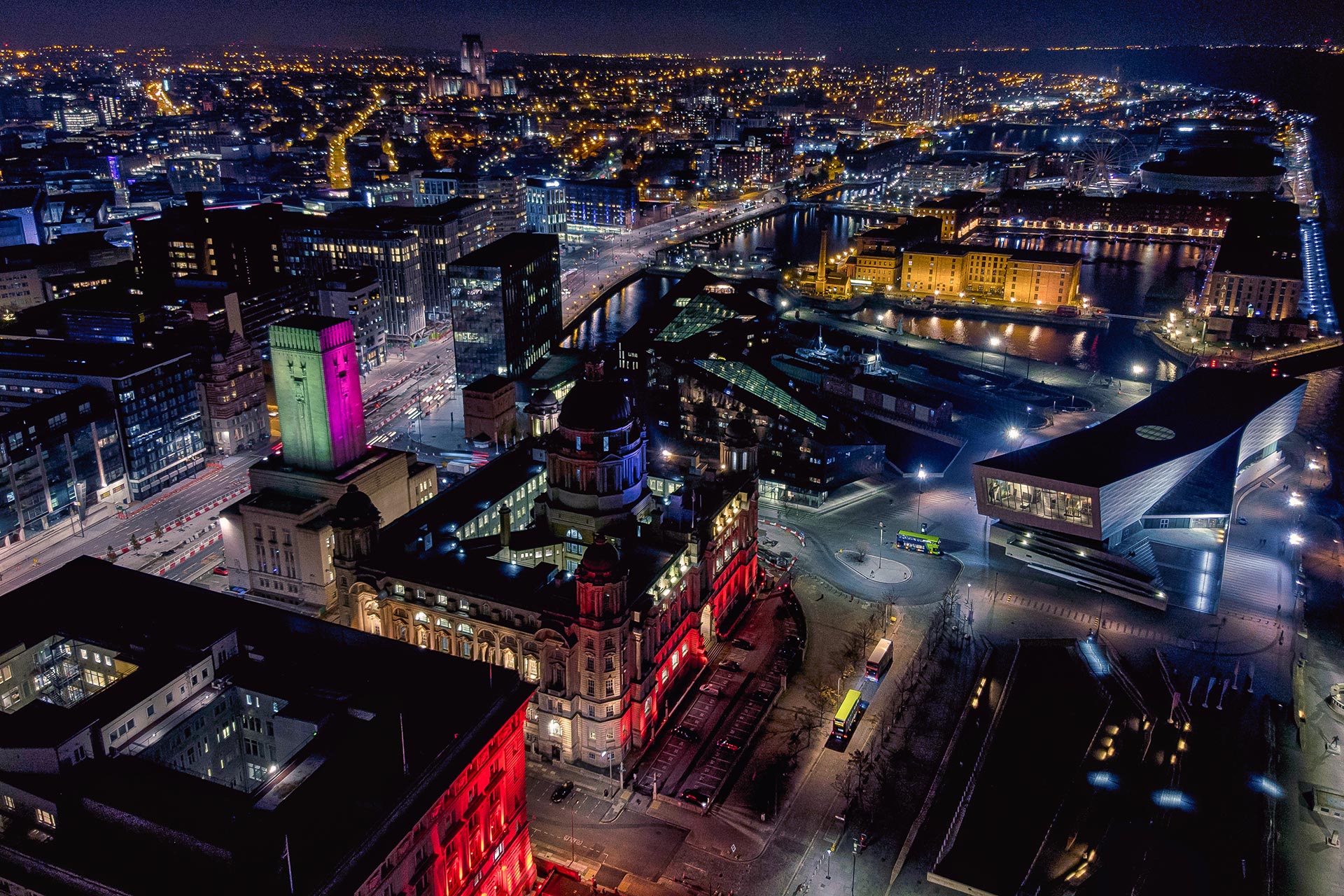 Nightime aerial shot of Liverpool showing the city all lit up