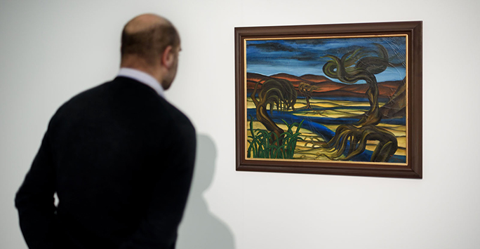 A man viewing a painting at the Surrealism in Egypt exhibition in Tate Liverpool